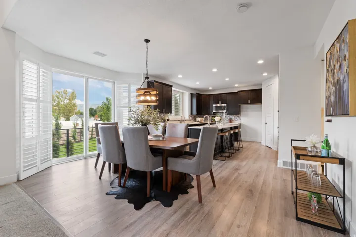 Light wood-finish flooring throughout, recessed lighting, and a contemporary pendant light fixture