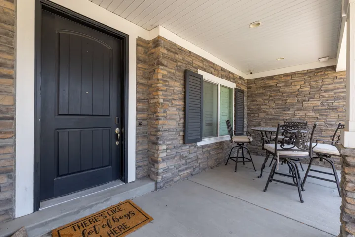 Stone facade accents a covered front porch with recessed lighting