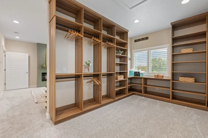 Custom wood-finish built-in shelving, integrated hanging rods, and ample floor space