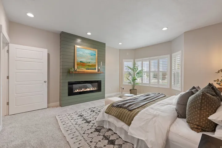 Built-in electric fireplace with green shiplap accent wall and wood mantel