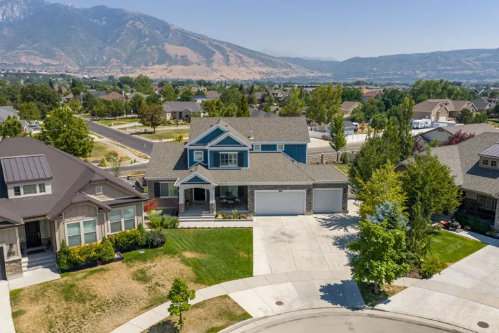 Two-story residence featuring a blue exterior with white trim, a multi-car driveway, and an attached two-car garage