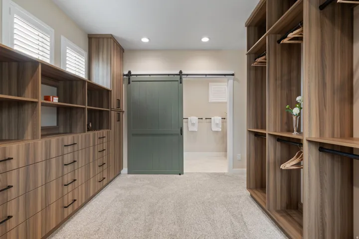 Custom closet system with wood-finish cabinetry, built-in drawers, and integrated shelving