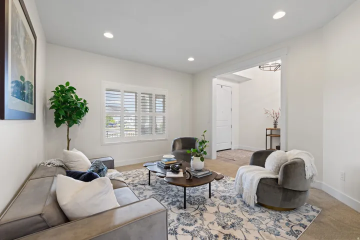 Recessed lighting, white plantation shutters, and light-toned walls