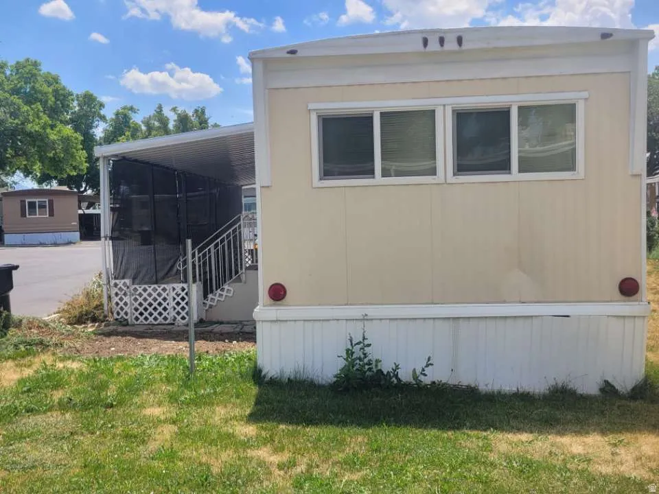 Exterior featuring horizontal siding, multiple windows, a covered patio, and metal railings