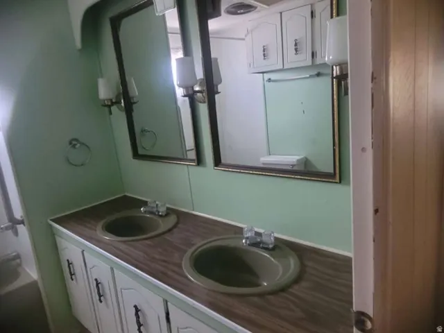 Dual vanity with integrated sinks, wood-finish countertop, and decorative wall-mounted mirrors