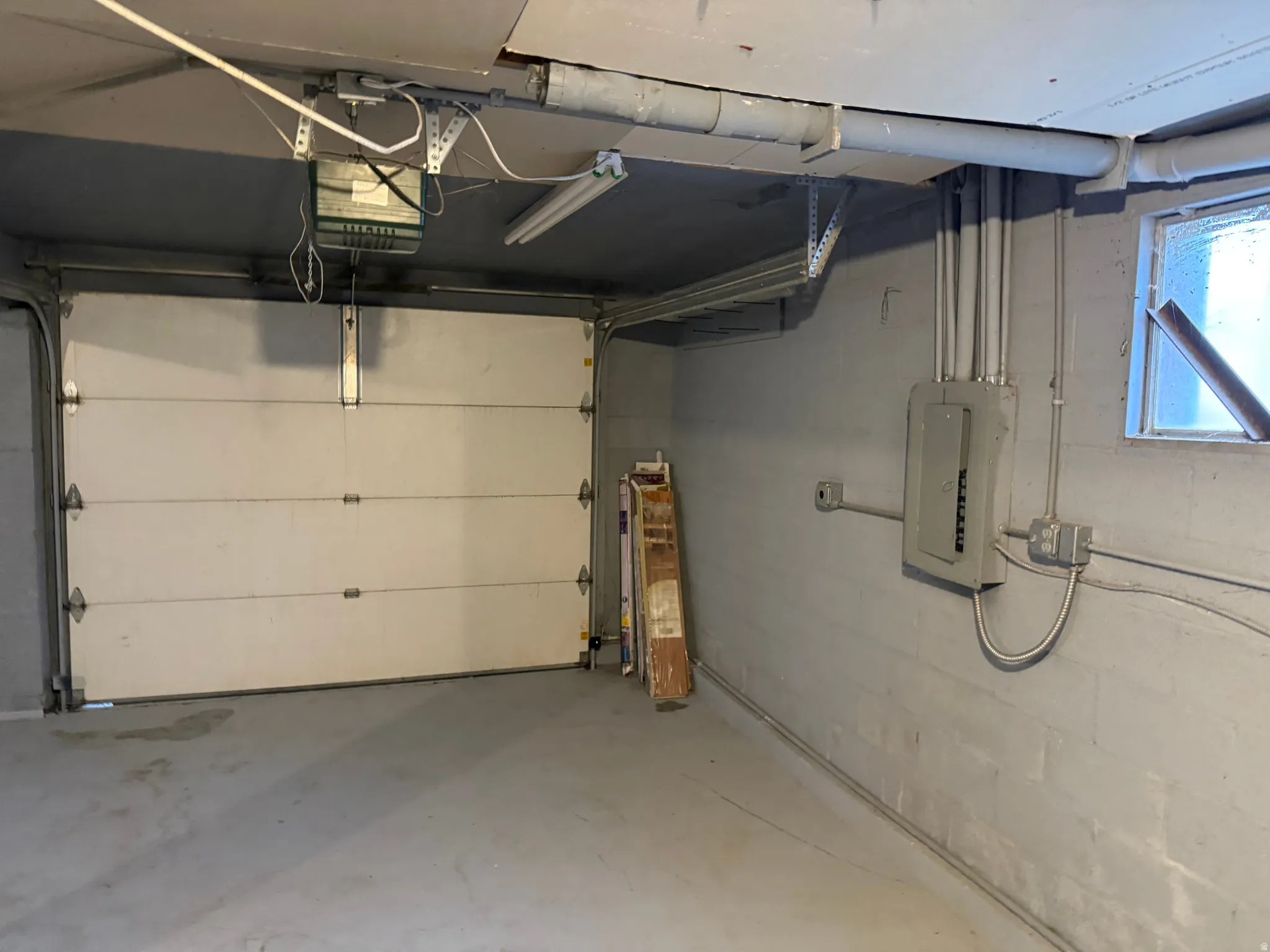 Attached garage featuring an overhead door and concrete flooring