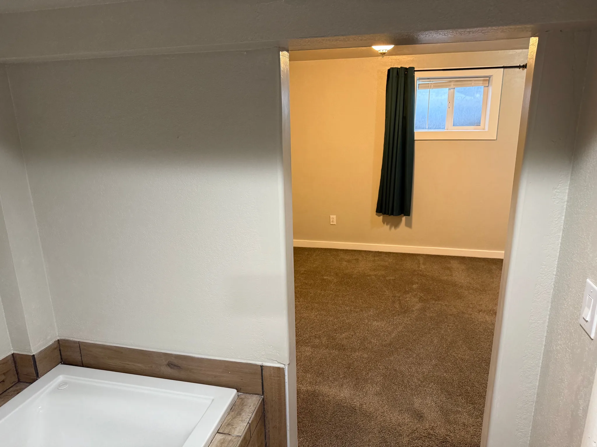White bathtub with wood-finish tile surround