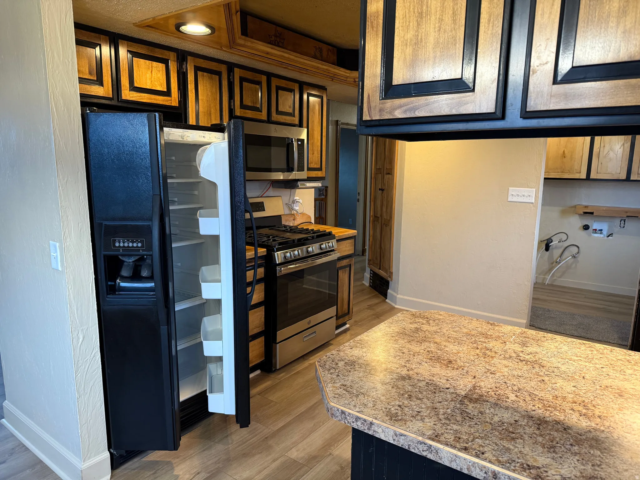 Kitchen featuring wood-finish cabinetry, stainless steel range with oven, and a built-in microwave