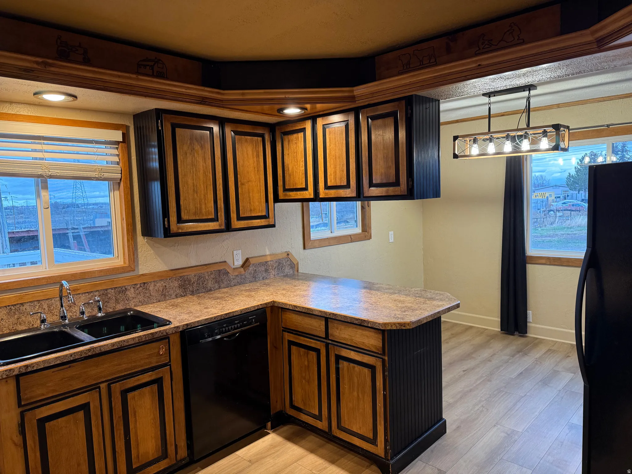 Kitchen featuring wood-finish cabinetry, built-in dishwasher, recessed lighting, and a linear pendant fixture