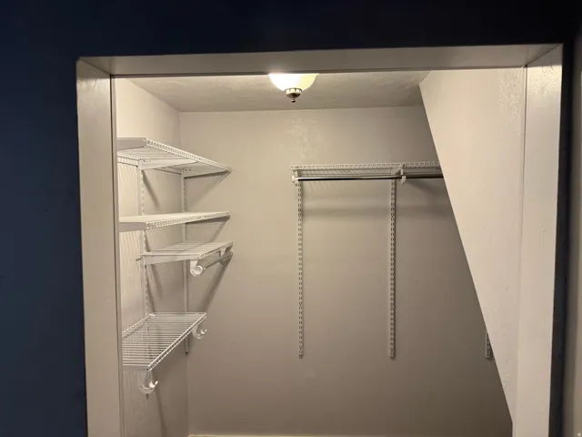 Built-in wire shelving, integrated hanging rods, and overhead lighting