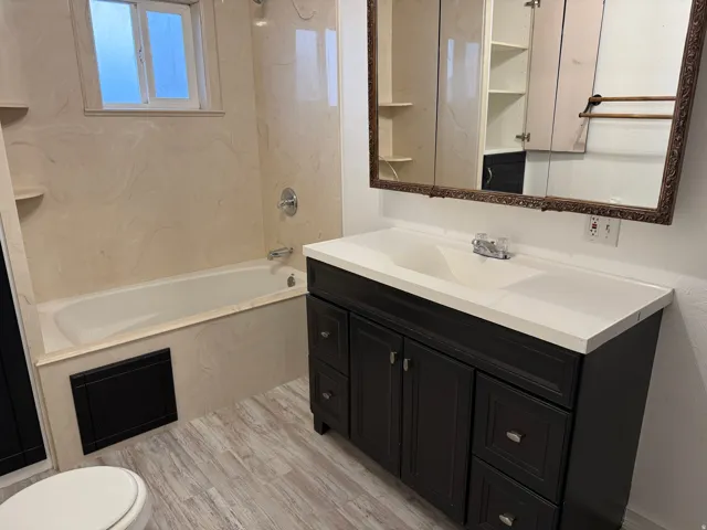 Dark wood-finish vanity with an integrated sink and white countertop
