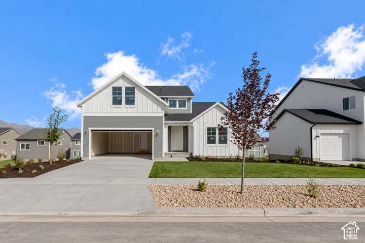 Contemporary exterior with mixed siding, attached two-car garage, concrete driveway, and manicured landscaping