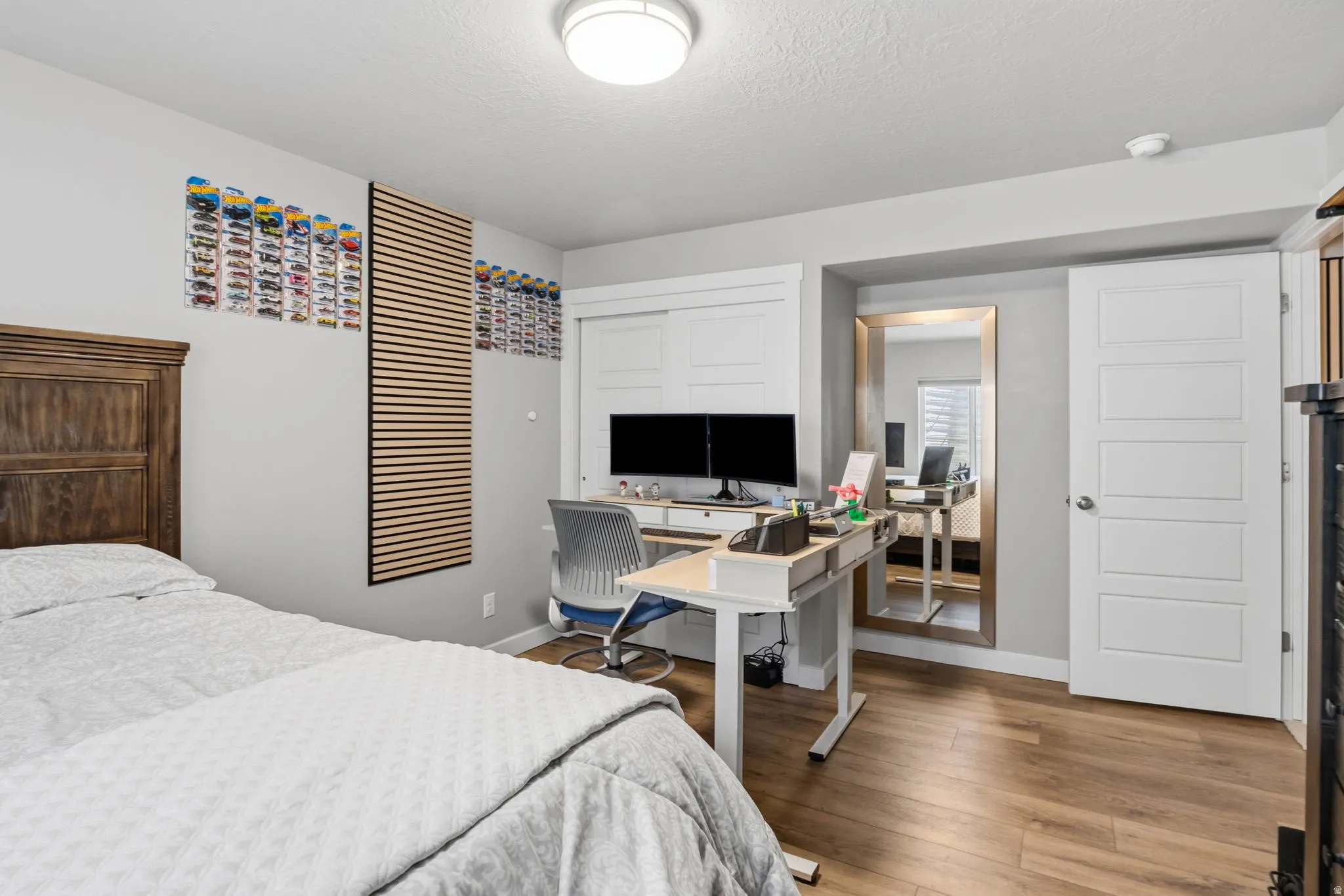 Wood-finish flooring, white paneled doors, ceiling-mounted lighting, and a built-in desk area