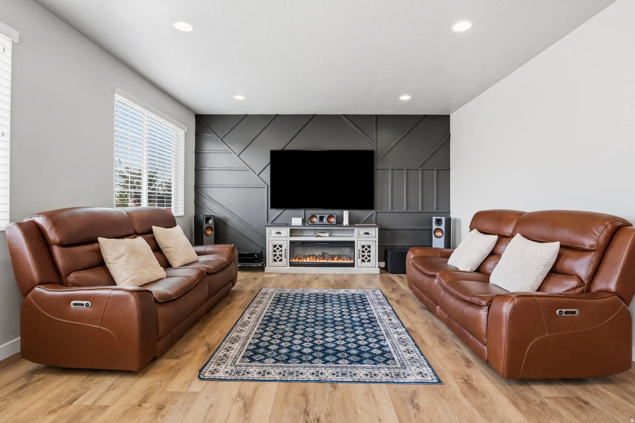 Wood-finish flooring, recessed ceiling lighting, and a feature wall with geometric paneling