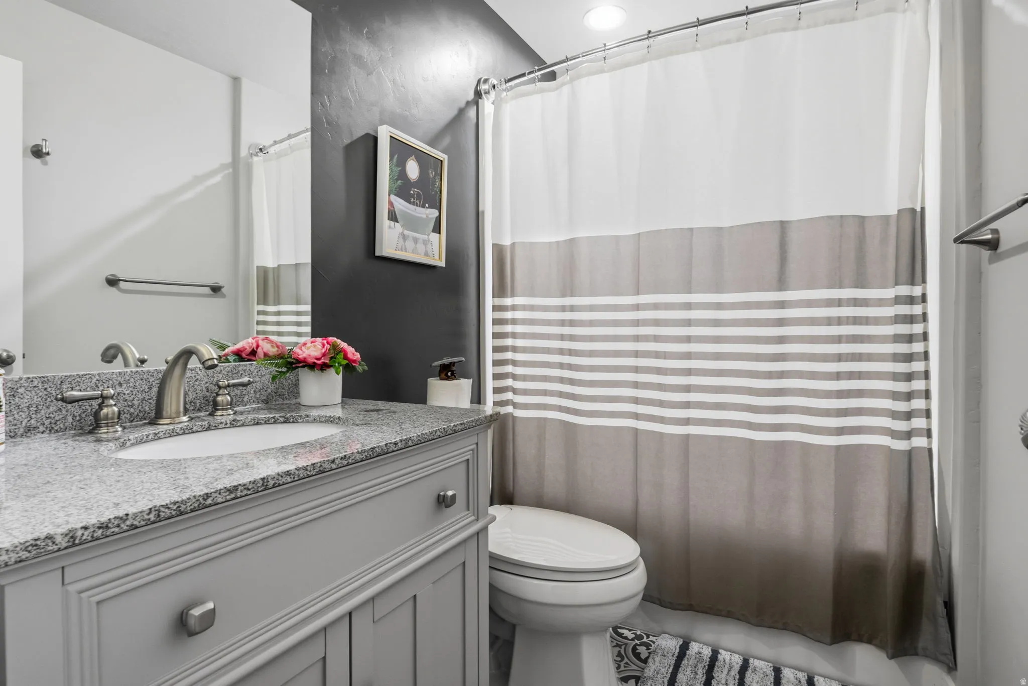 Vanity with a granite countertop, undermount sink, and brushed nickel faucet