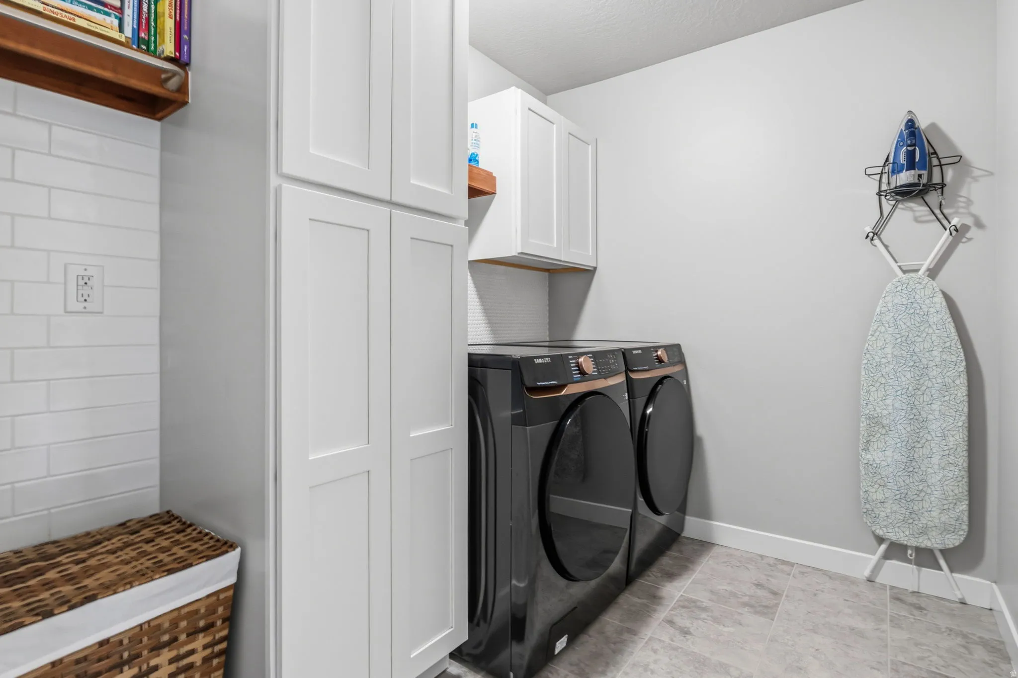 White shaker cabinetry, wood-finish shelving, subway tile backsplash, and tile flooring