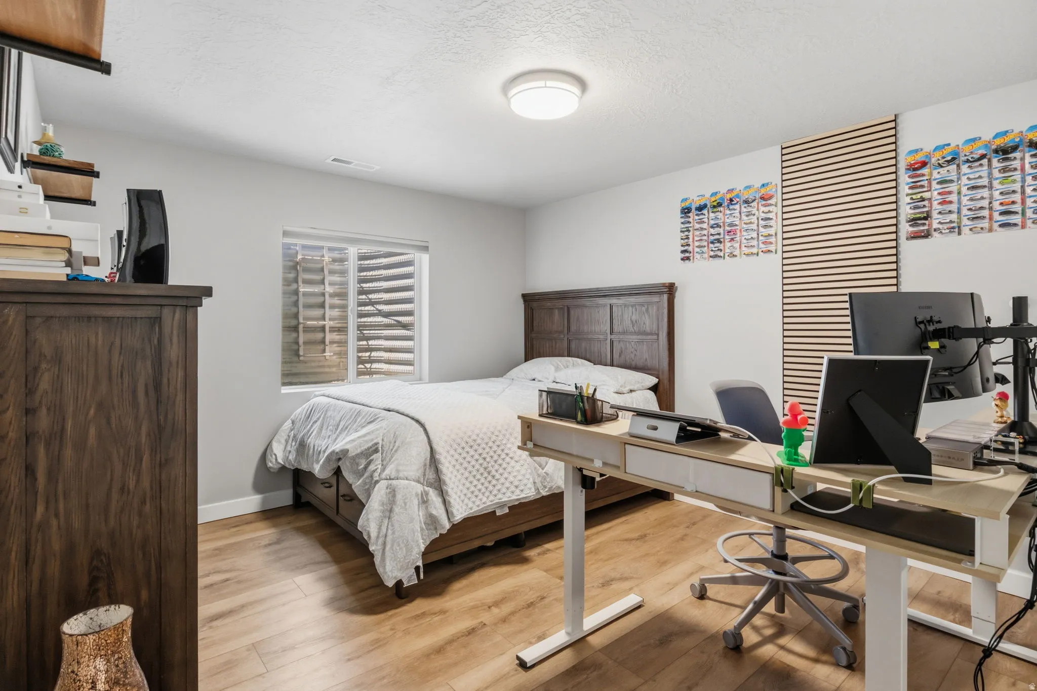 Wood-finish flooring, recessed window, overhead flush-mount lighting, and white wall finishes