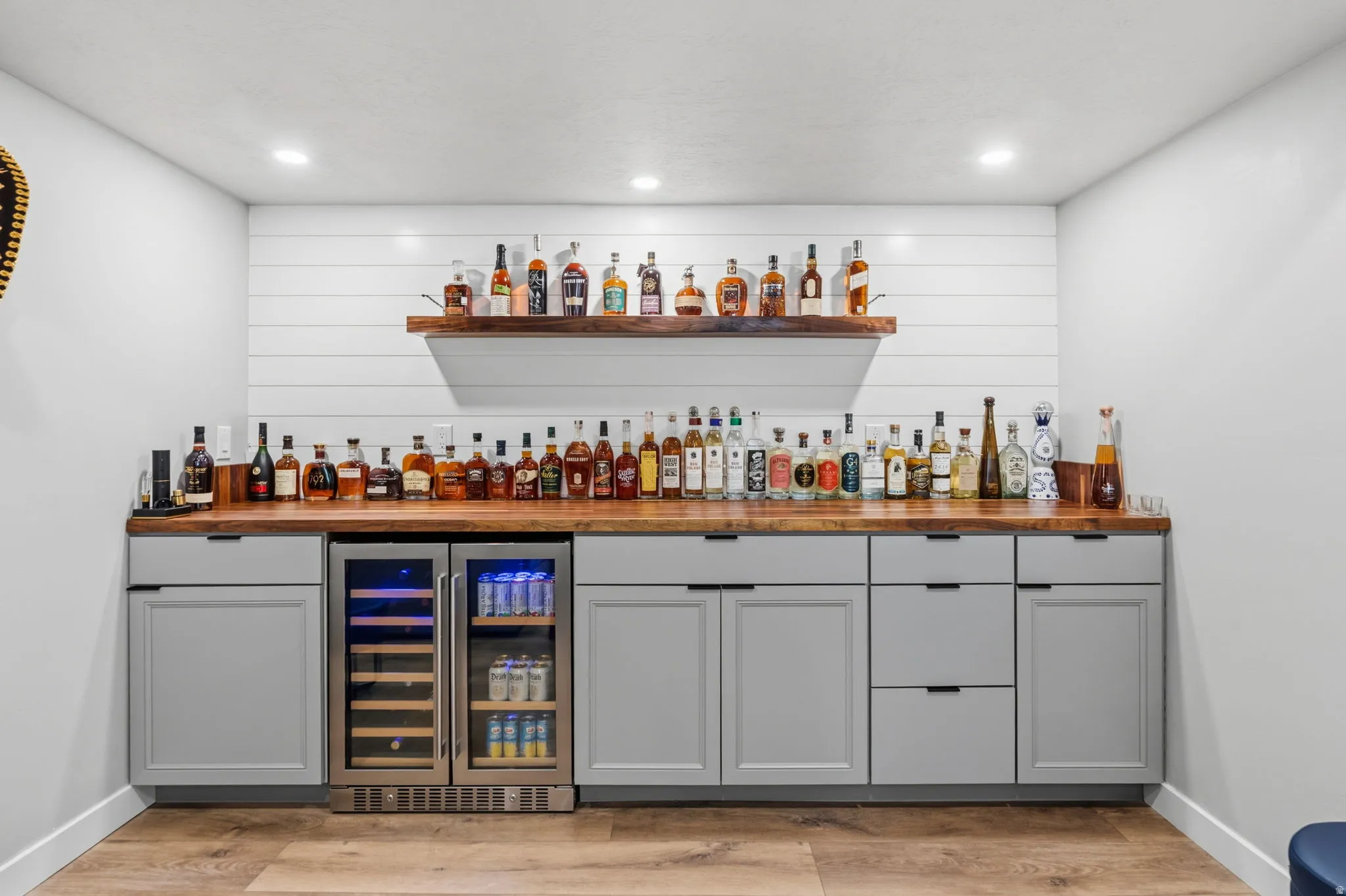 Built-in bar with gray cabinetry, wood-finish countertops, and undercounter beverage coolers