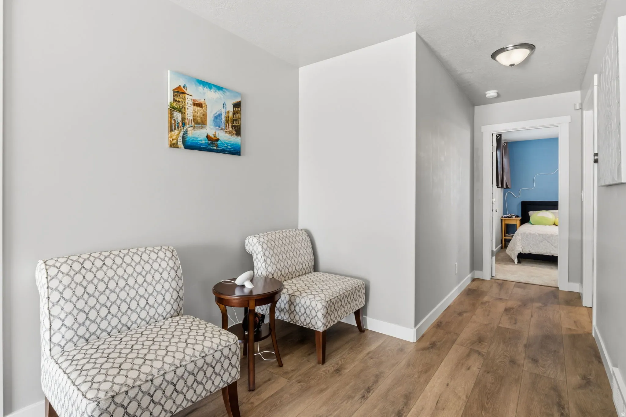 Wood-finish flooring, white trim, and a semi-flush ceiling light fixture
