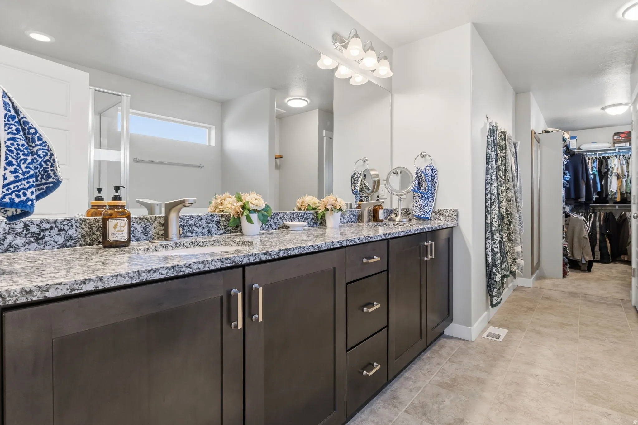 Dual vanity with granite countertop, undermount sinks, and dark wood-finish cabinetry