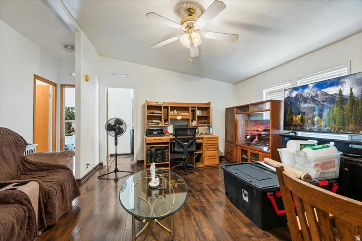 Sloped ceilings complement wood-finish flooring, featuring a ceiling fan with integrated lighting