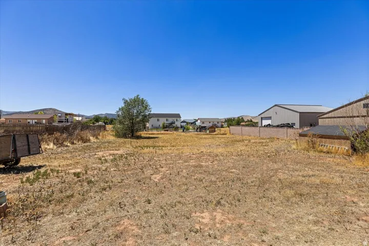 Expansive land parcel featuring arid ground cover and a clear sky