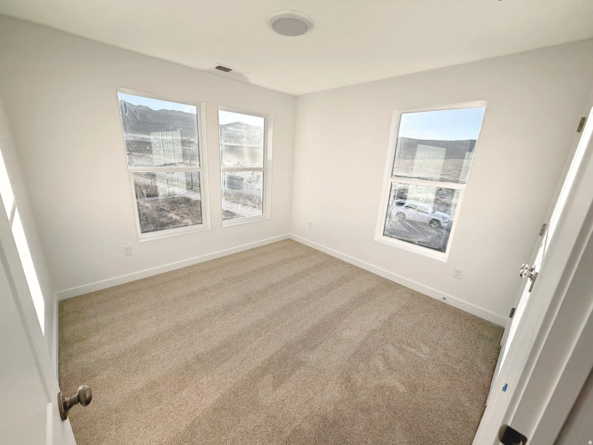 Light-filled interior space with neutral-toned carpet flooring