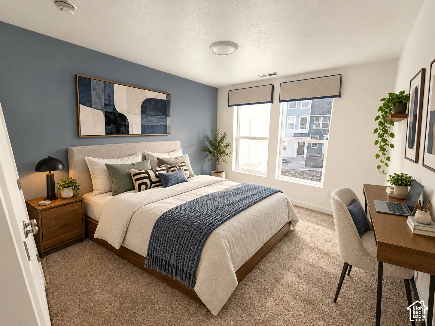 Bedroom featuring a blue accent wall, dual windows with fitted fabric valances, and neutral carpeting