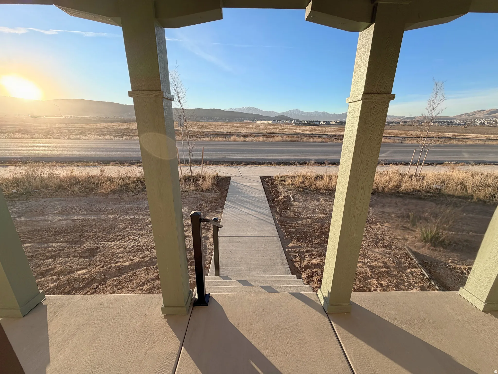 Covered outdoor porch with concrete flooring and angled support columns