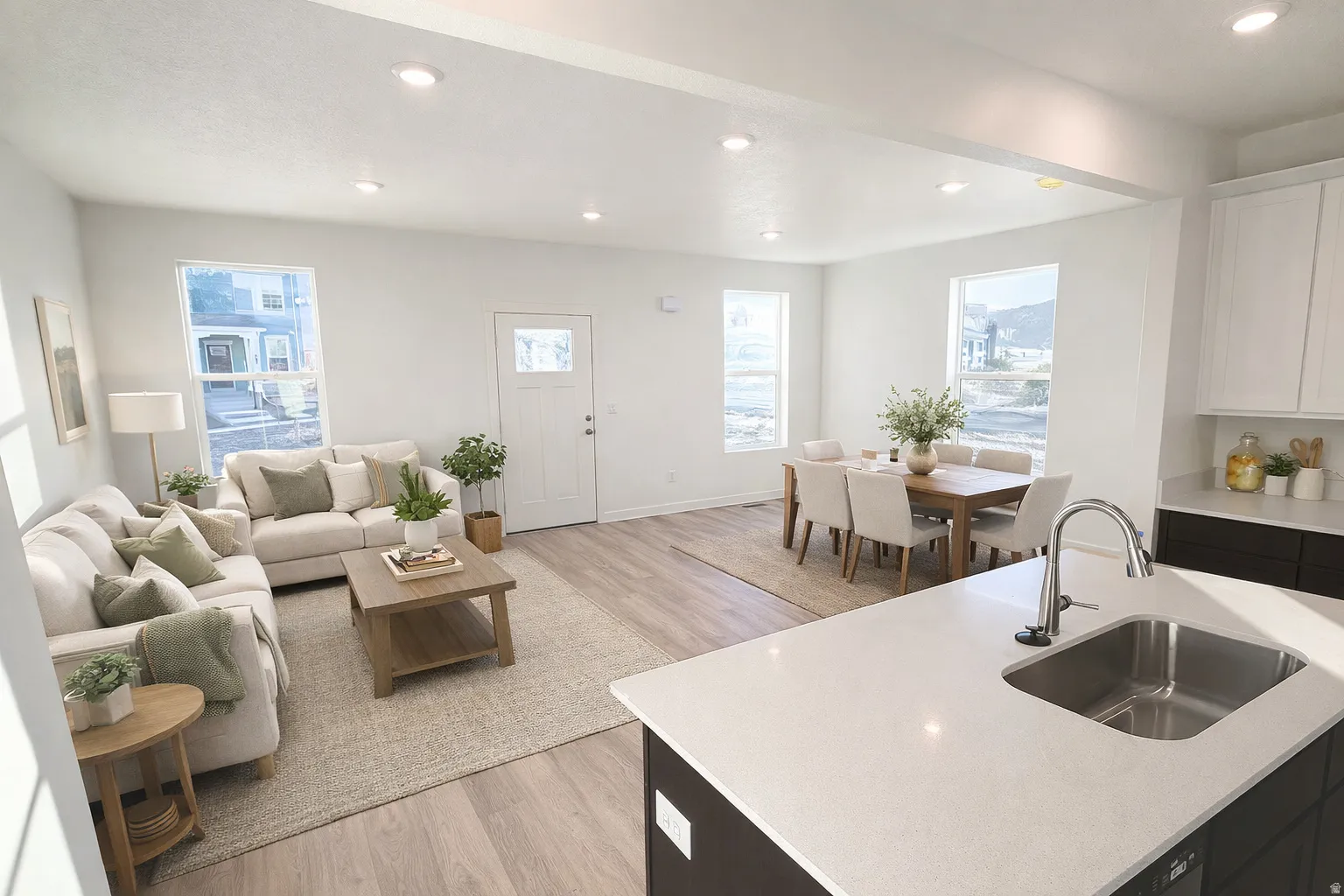 Open-concept living space featuring wood-finish flooring, recessed lighting, and ample natural light through multiple windows