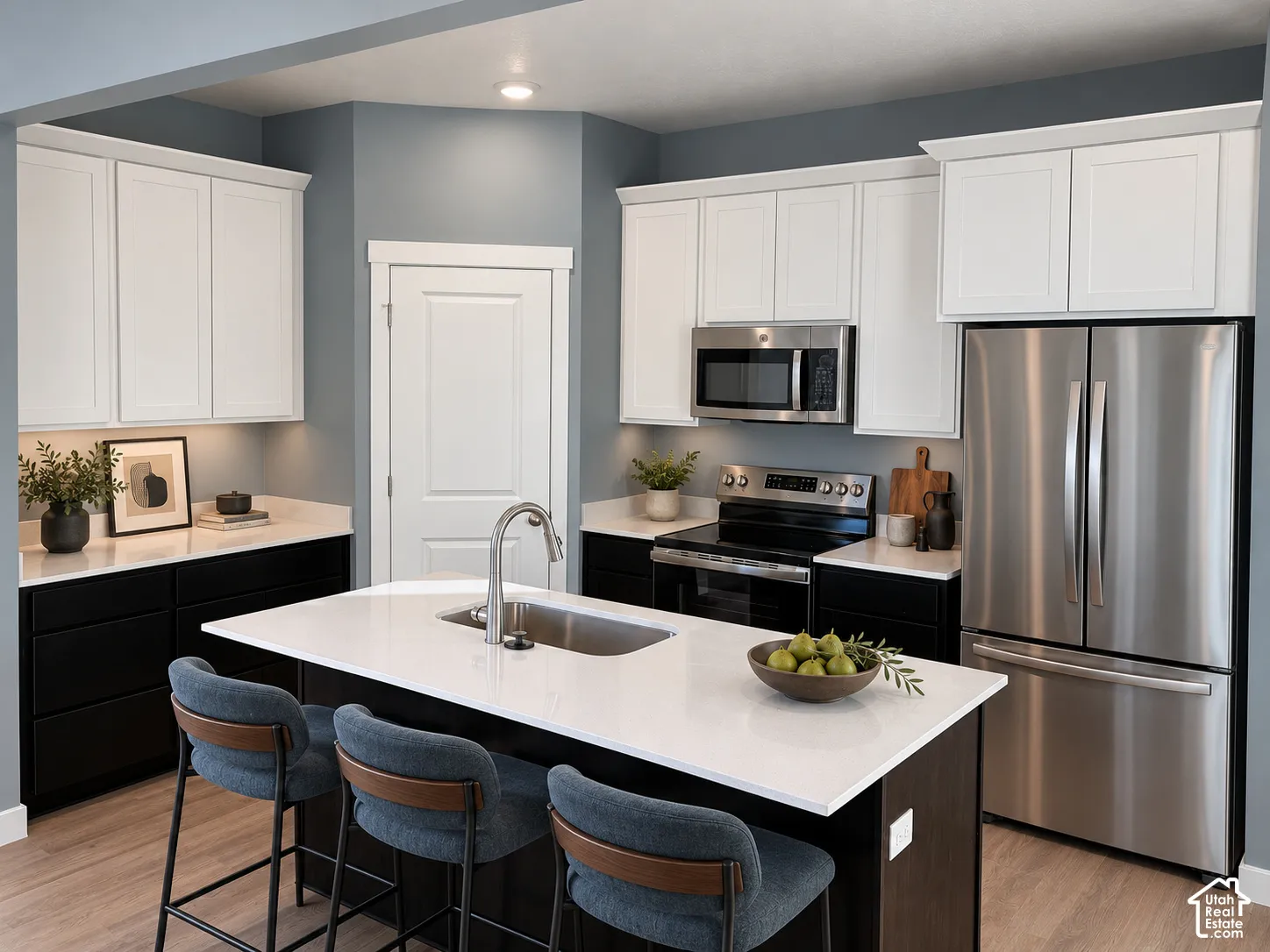 Kitchen featuring two-tone cabinetry, quartz countertops, central island with stainless steel under-mount sink, and stainless steel appliances