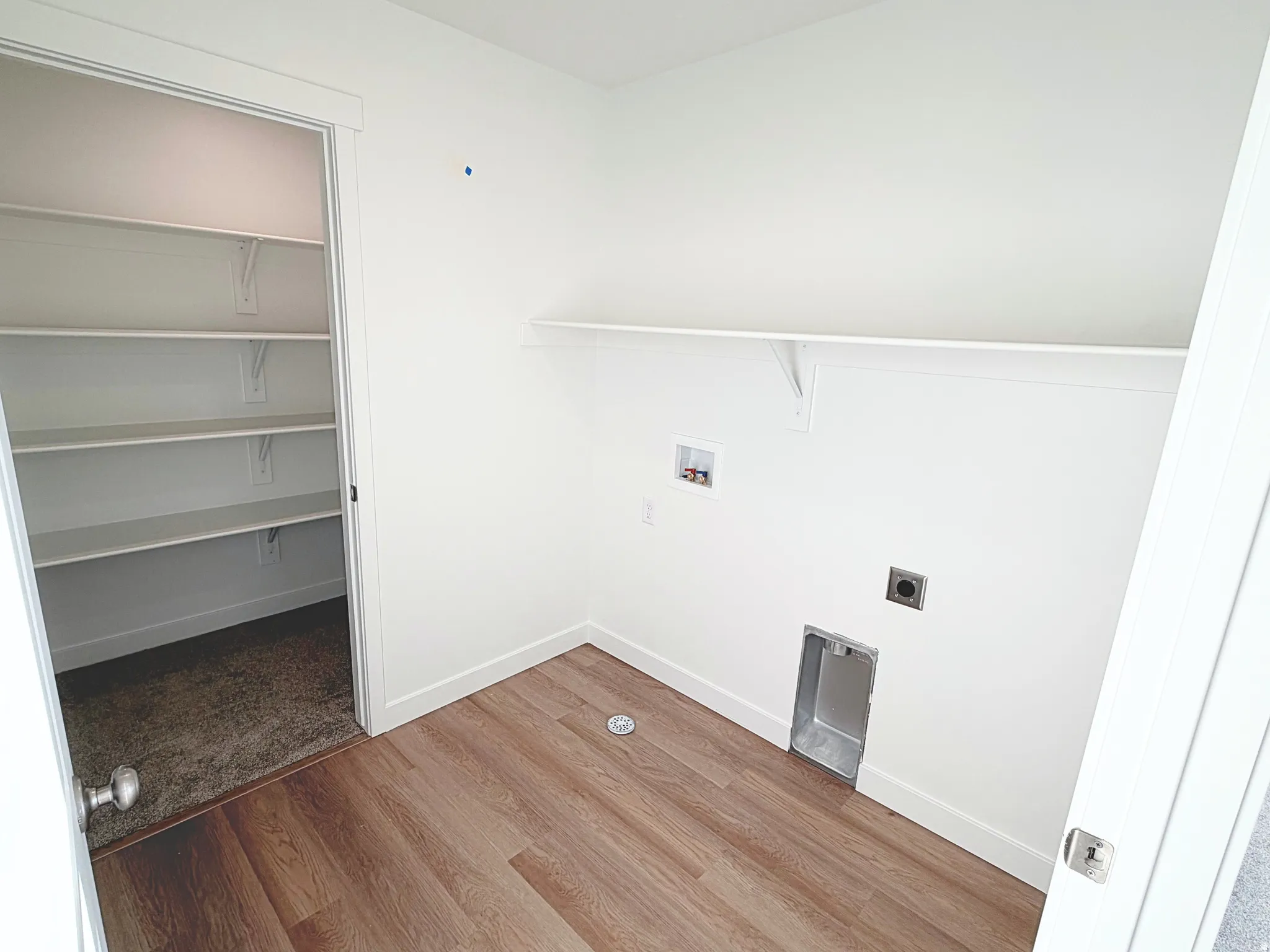 Wood-finish flooring, white walls, built-in shelving, laundry hookups