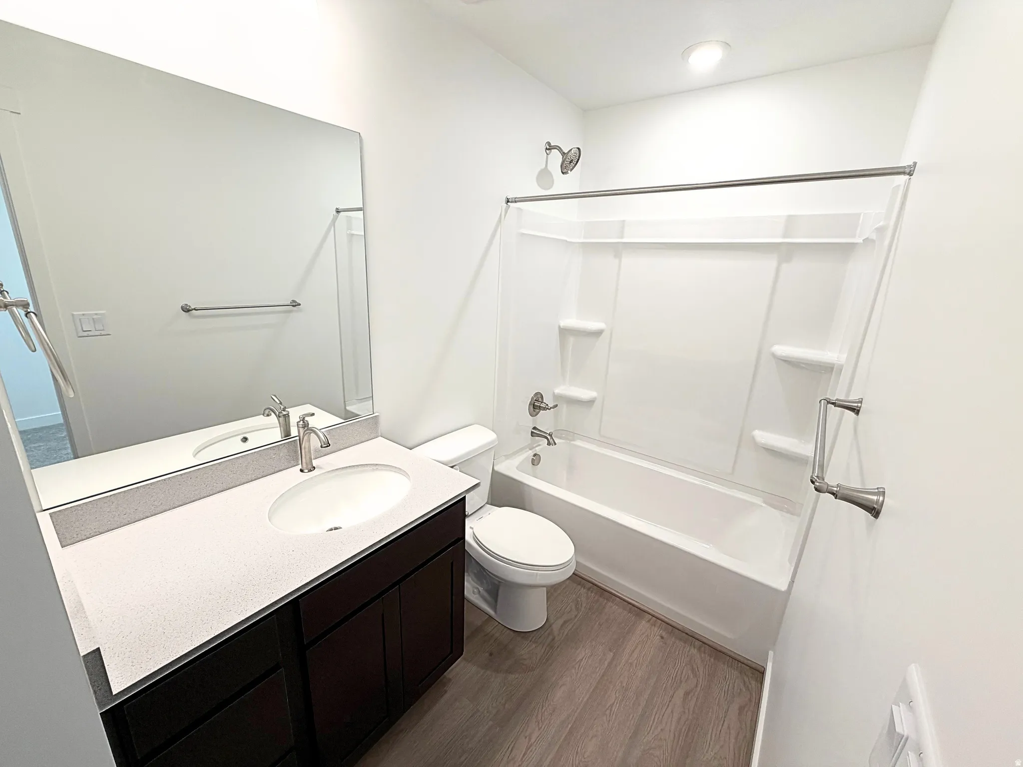Vanity with an oval undermount sink, brushed nickel faucet, and composite countertop