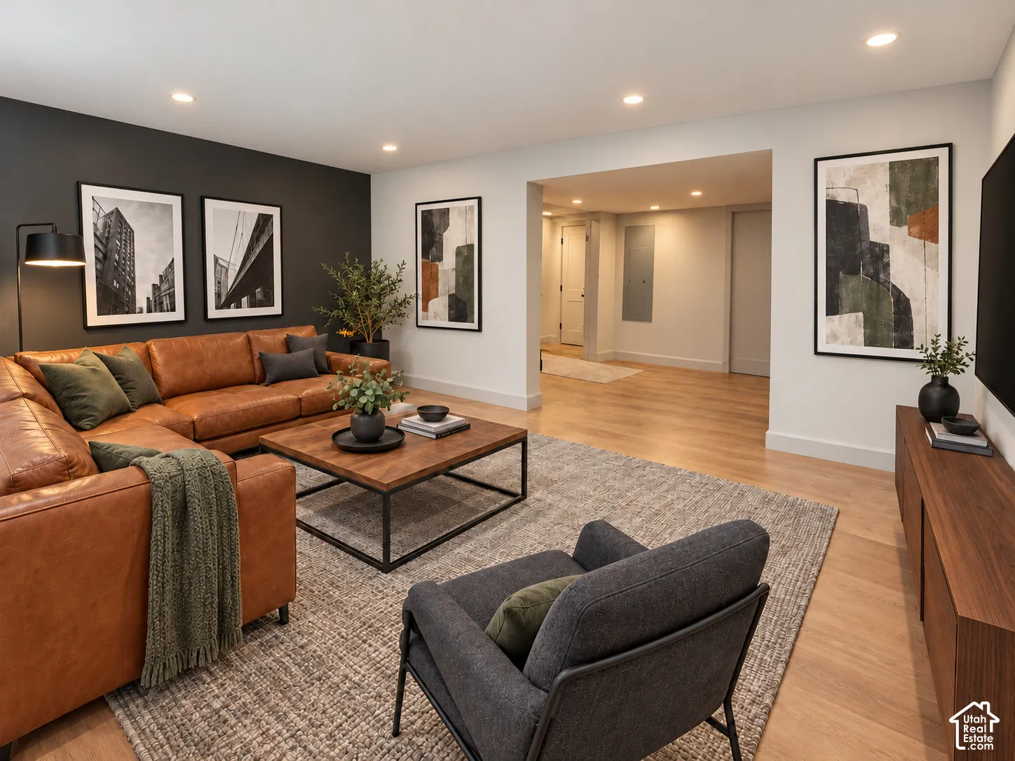 Neutral-toned room featuring recessed lighting, wood-finish flooring, and a contrasting dark charcoal accent wall
