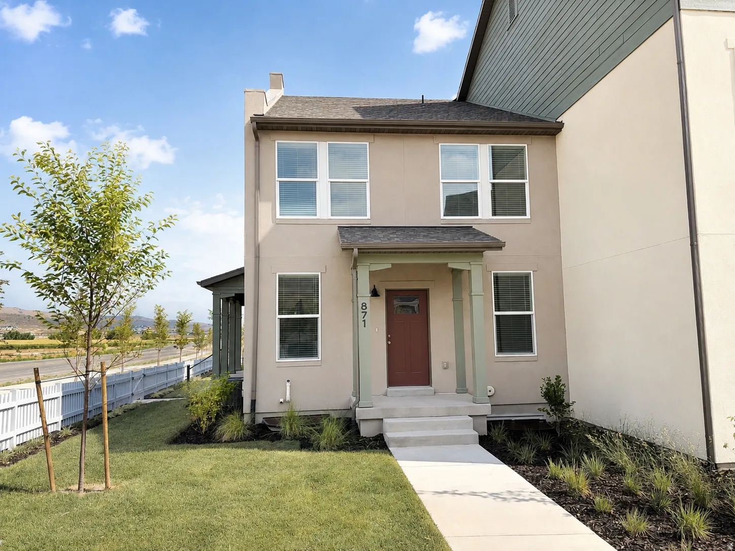 Stucco exterior with a covered porch, solid entry door, and multi-pane windows