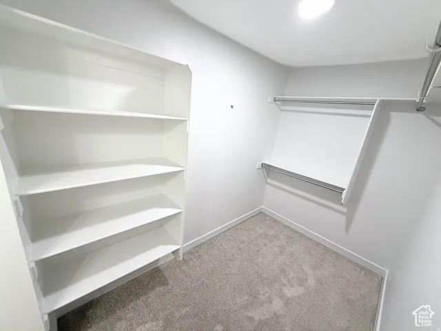 Walk-in closet featuring built-in shelving, dual hanging rods, and recessed lighting