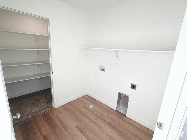 Wood-finish flooring, white walls, built-in shelving, laundry hookups