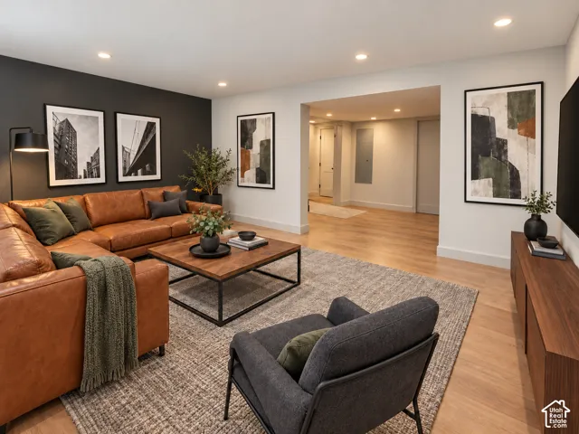 Neutral-toned room featuring recessed lighting, wood-finish flooring, and a contrasting dark charcoal accent wall