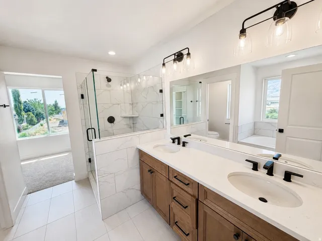 Dual vanity with undermount sinks, stone countertops, and matte black fixtures