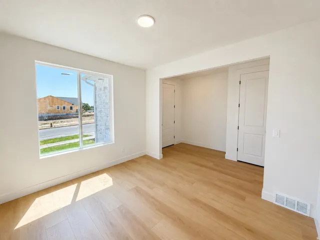 Recessed lighting, wood-finish flooring, white walls, white trim, and a window with white framing