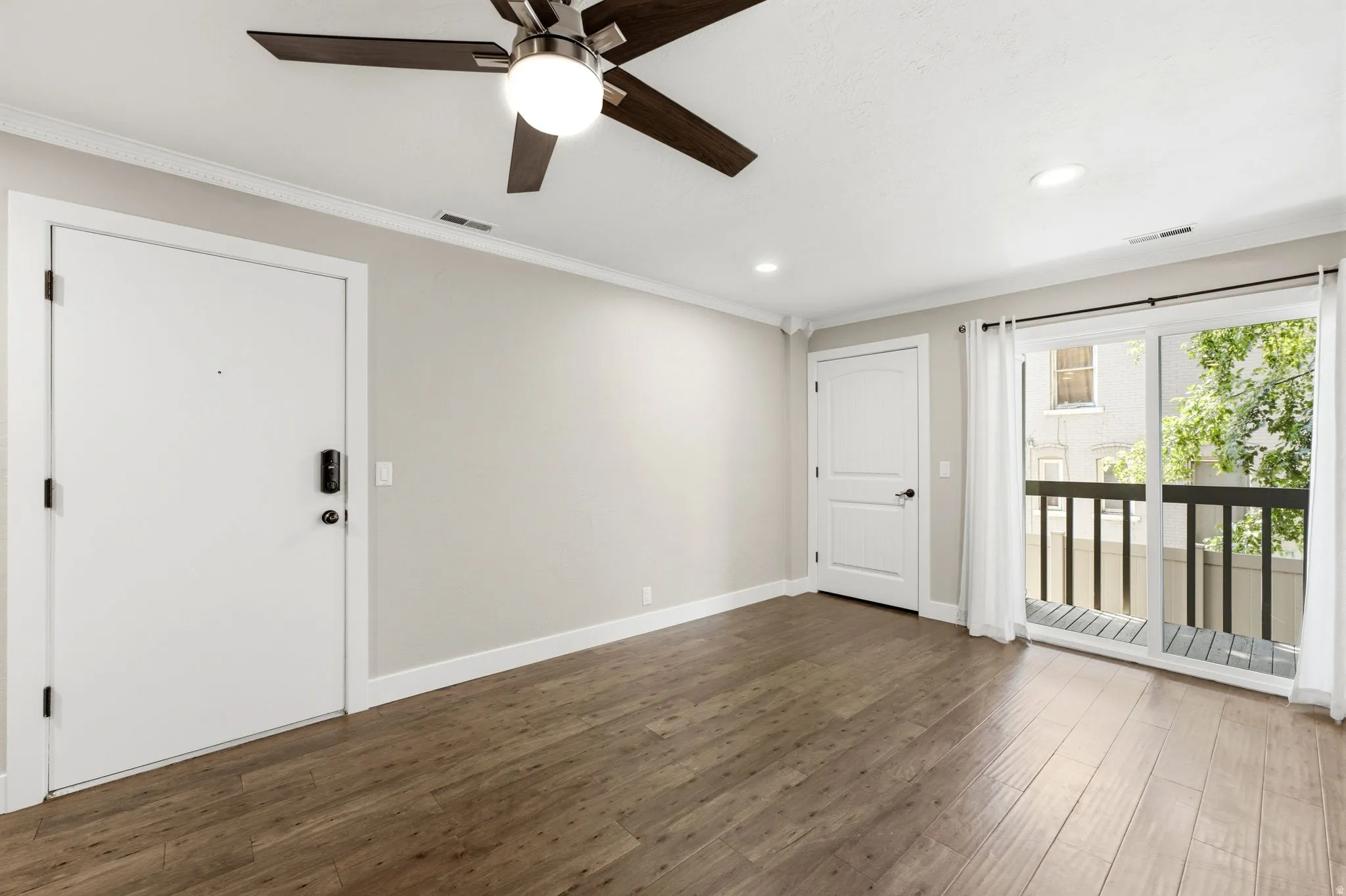 Wood-finish flooring, recessed lighting, and a ceiling fan with integrated lighting