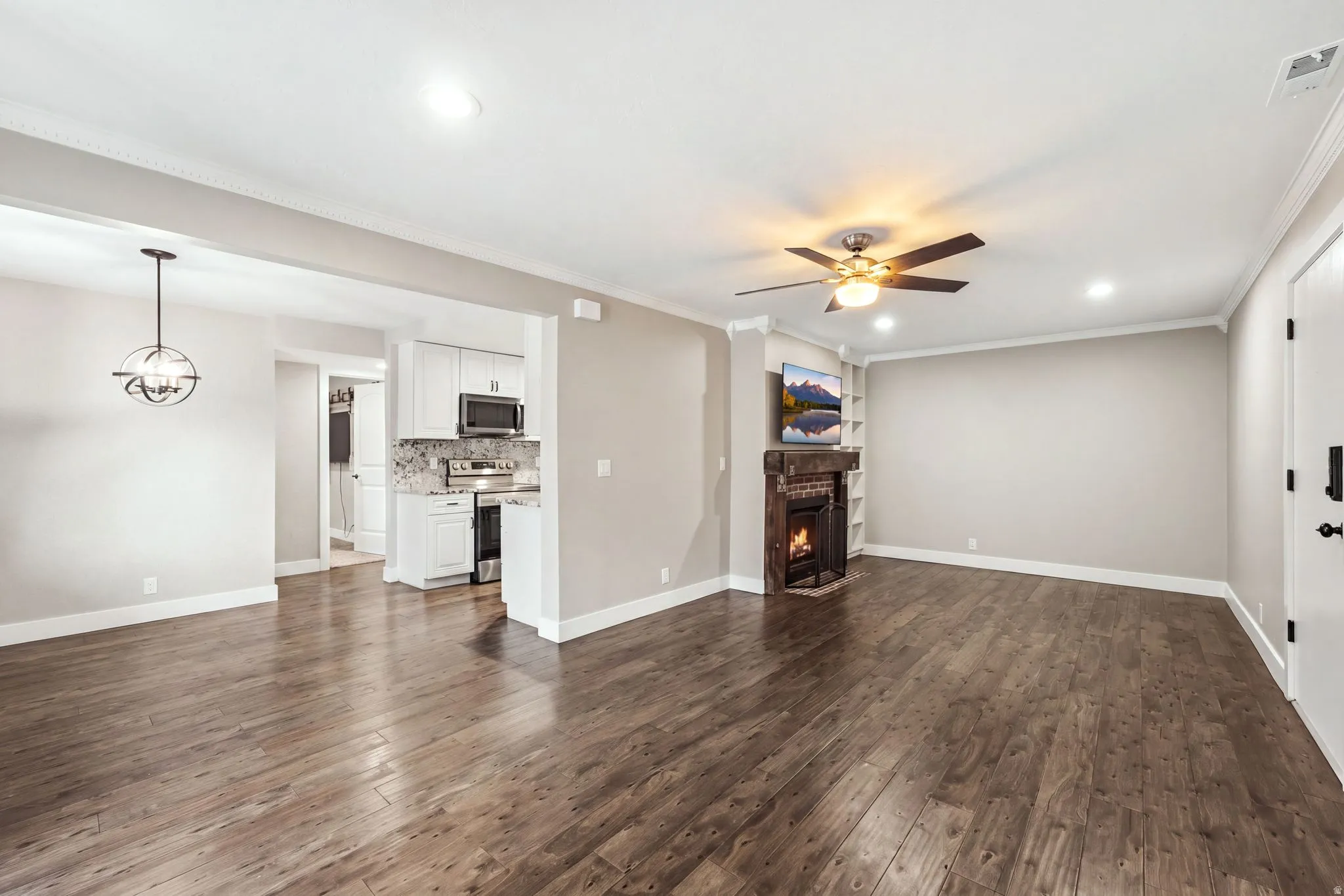 Wood-finish flooring throughout, recessed lighting, and a corner fireplace with built-in shelving