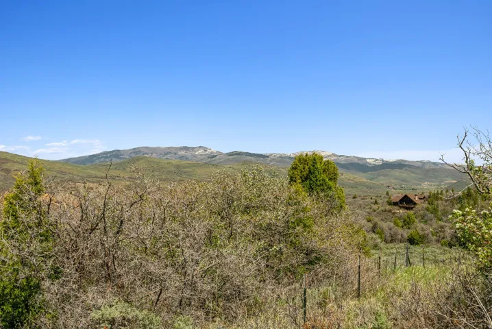 Expansive natural landscape with distant mountain ranges and a visible structure