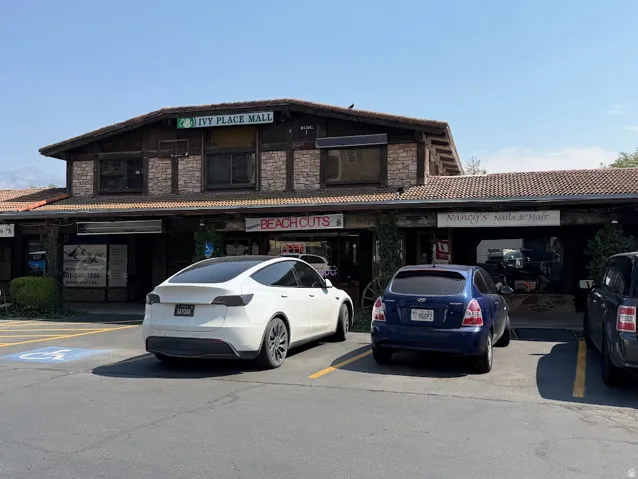 Commercial building featuring a terracotta-style roof, a combination of brick and timber-frame exterior, and ground-level retail storefronts