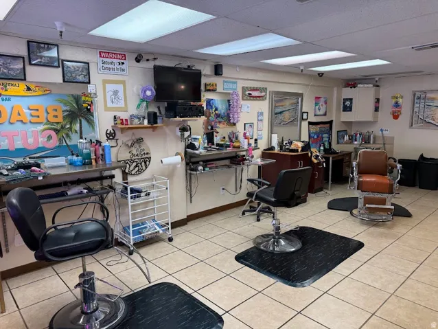 Tile flooring, recessed fluorescent lighting, wall-mounted shelving, built-in cabinetry, and a wall-mounted television display