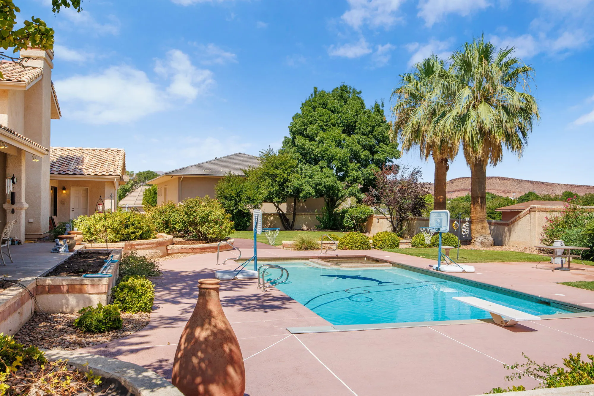 Expansive backyard featuring a swimming pool, diving board, and integrated spa