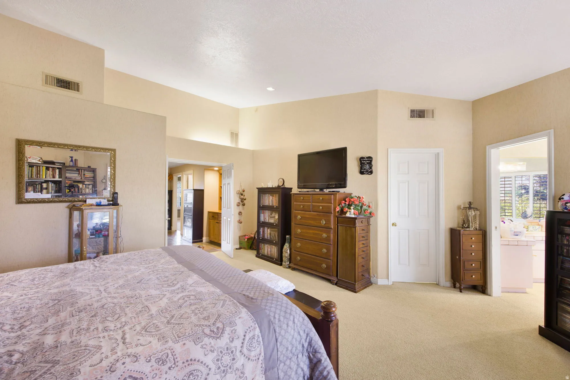 High ceilings with textured finish, carpeted flooring, and neutral wall tones