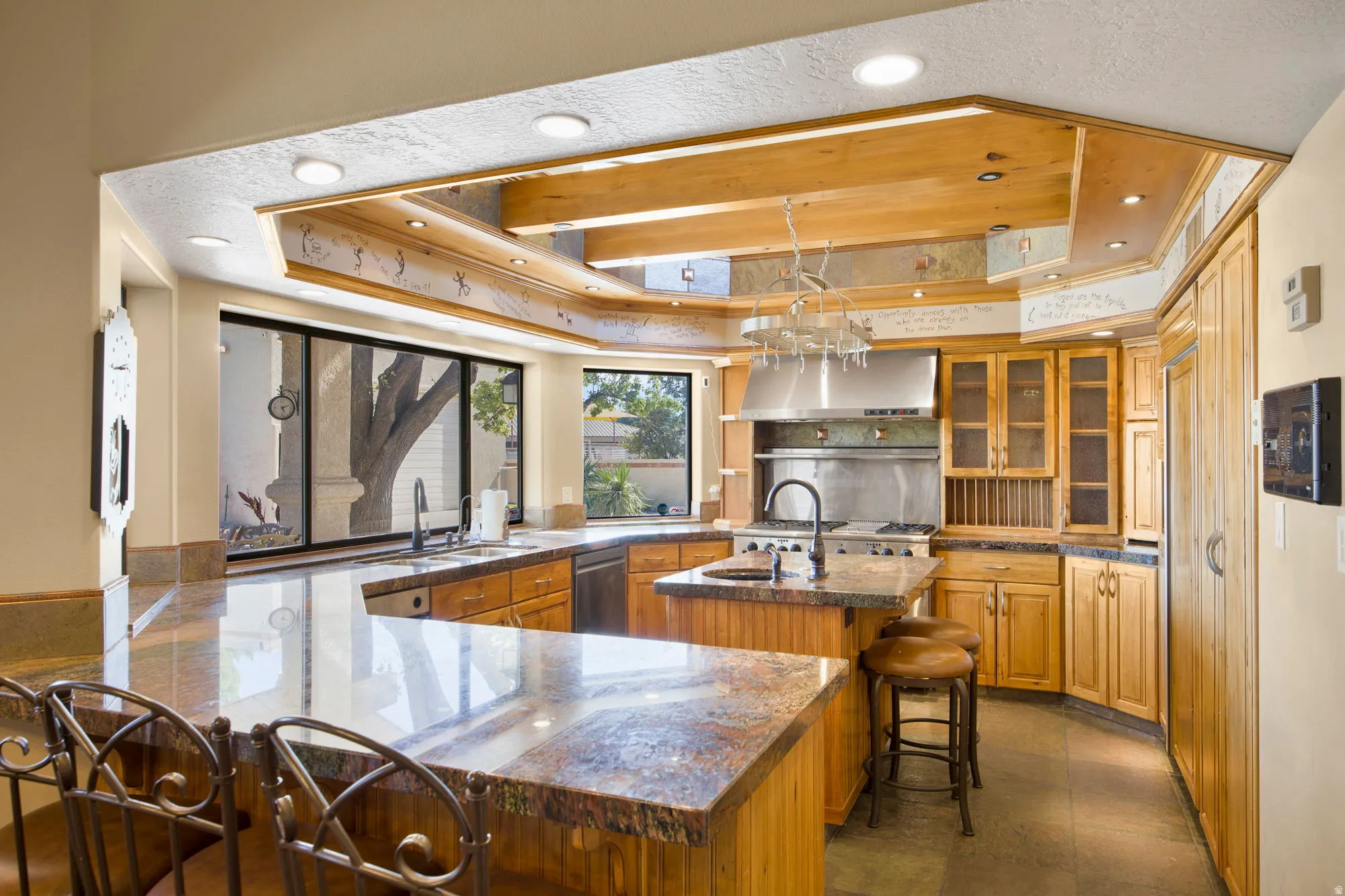 Kitchen featuring a large window, light wood cabinetry, granite countertops, a stainless steel range hood, and recessed lighting