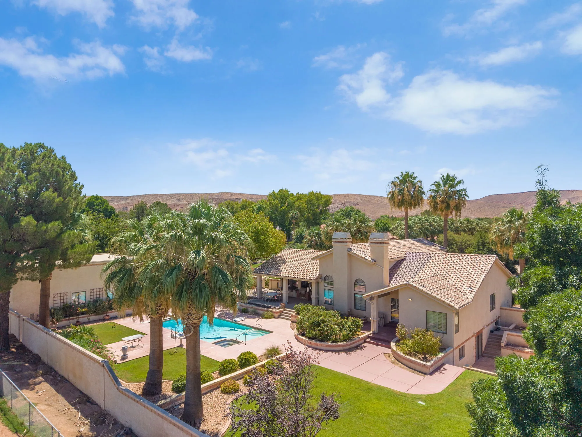 Exterior stucco finish, tile roofing, private swimming pool, mature palm trees, and established landscaping