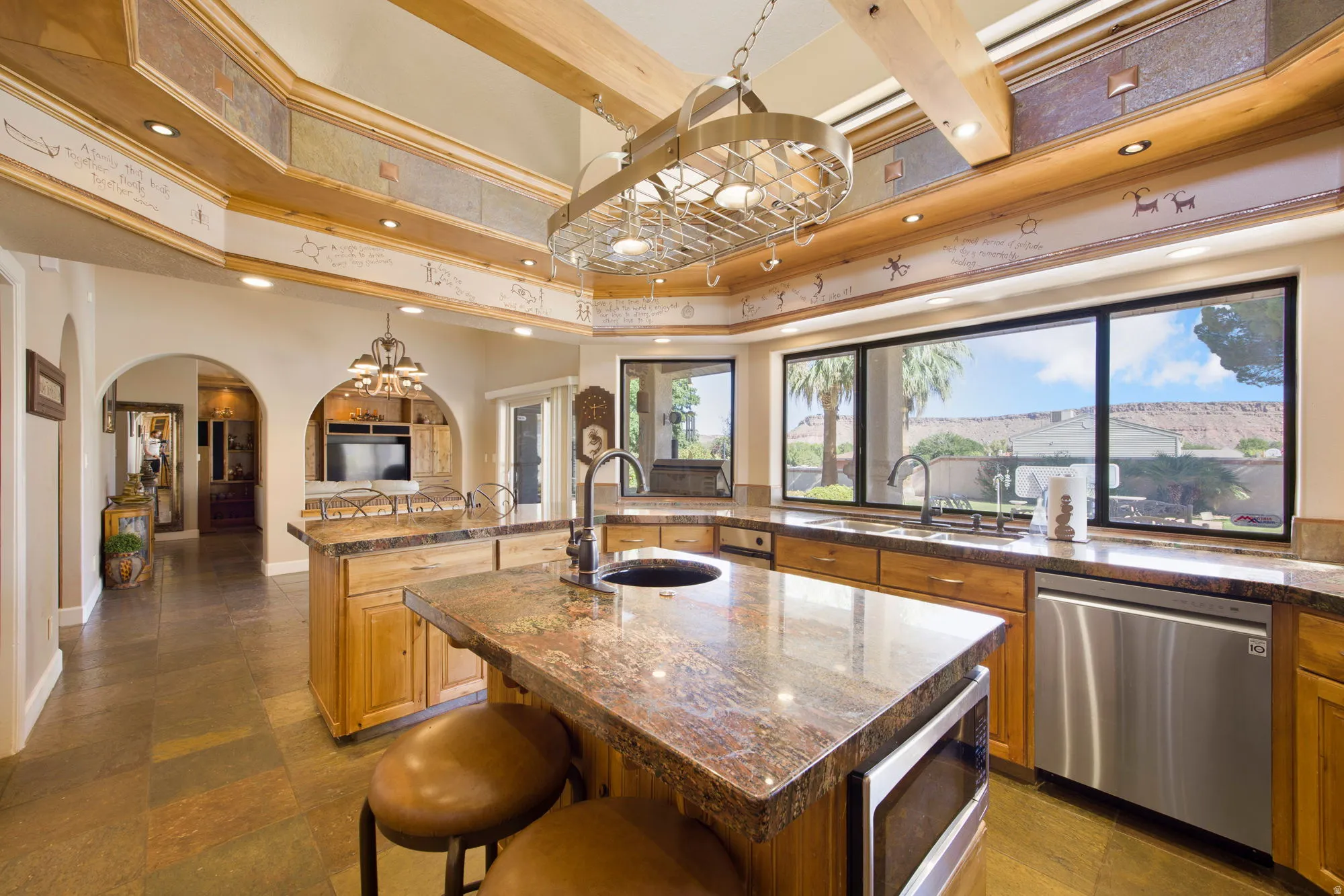 Expansive kitchen featuring a large island, wood cabinetry, granite countertops, and stainless steel appliances